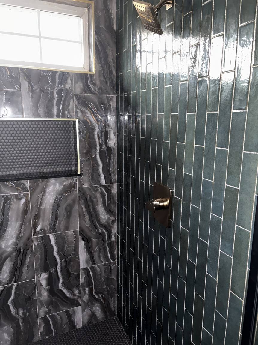 Green vertical tile and dark veined tile in the shower